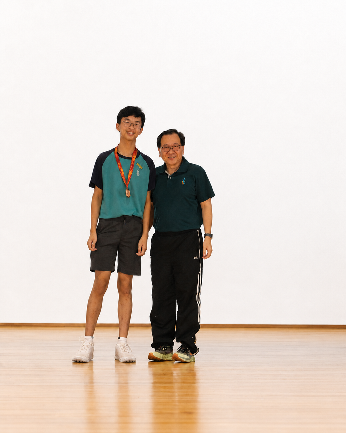 boy with medal stands next to principal